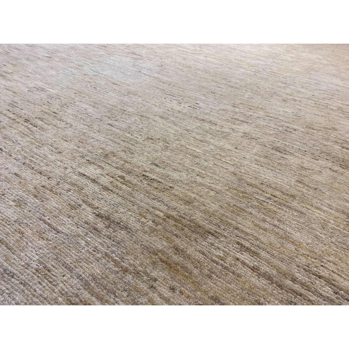 Close-up of the Gabbeh rug: light beige texture with fine, low-contrast lines