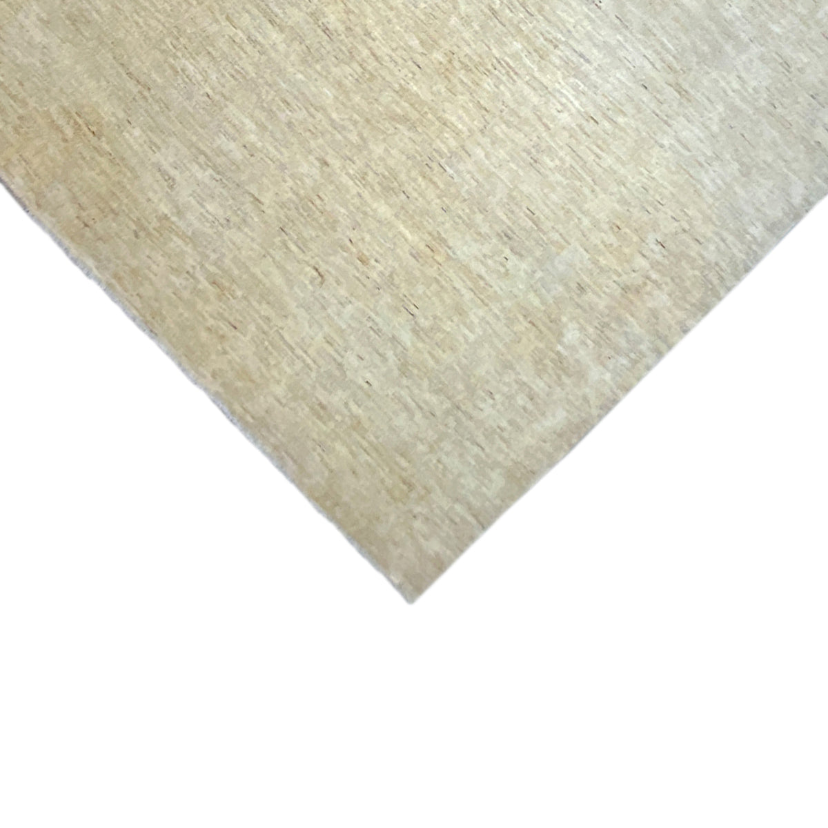 Corner of the Gabbeh rug in light beige, with a visibly speckled texture along the edge