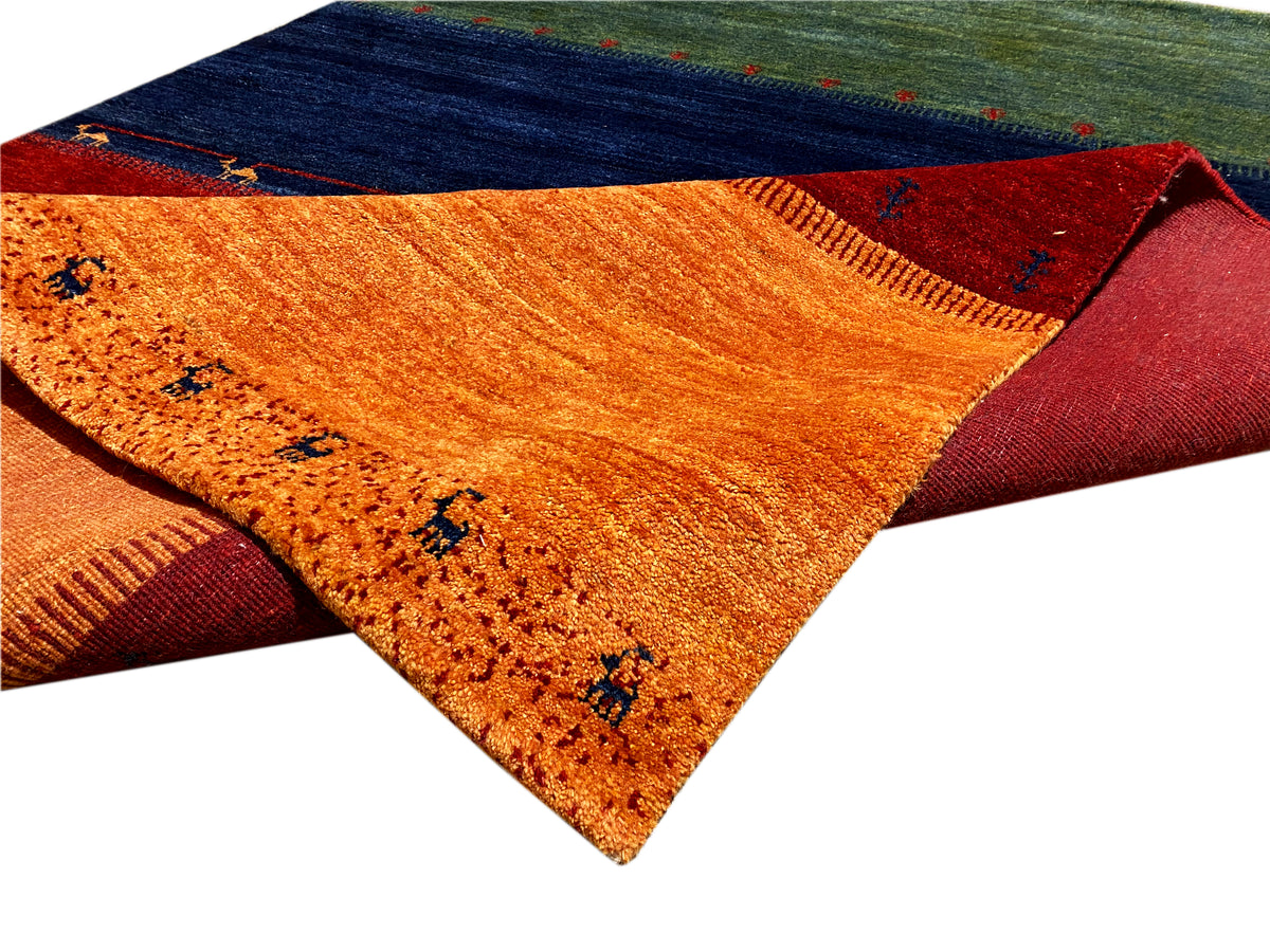 Gabbeh-Teppich 230x172 cm Detail mit geklapptem Rand in Orange, Rot und Blau