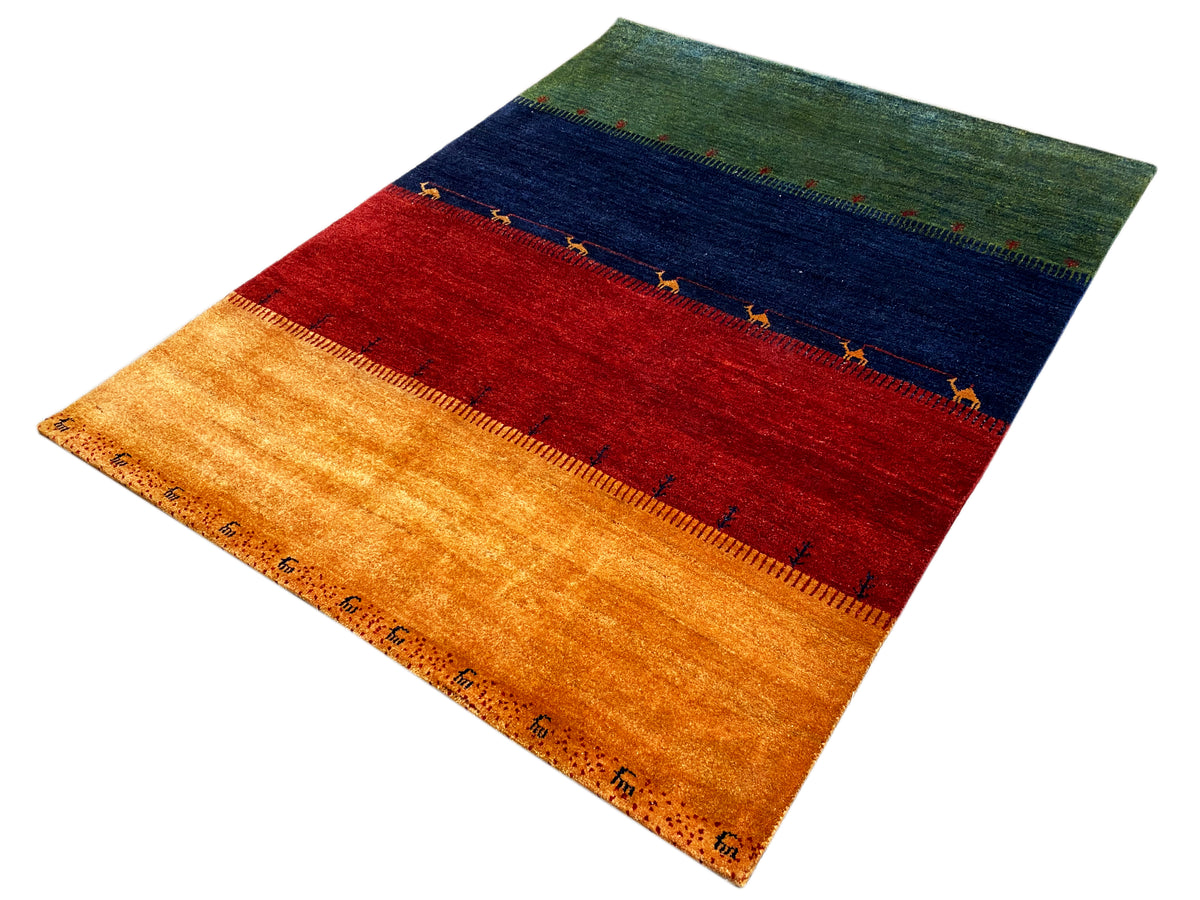 Teppich in Schrägsicht mit Streifen in Ocker, Rot, Dunkelblau und Grün, dekorativer Kante.