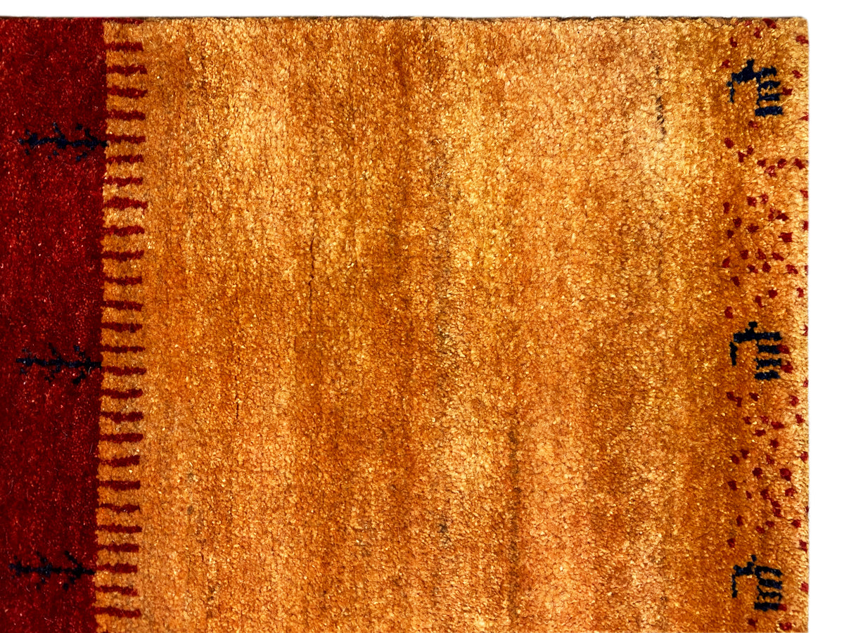 Teppichoberfläche im Close-up: goldener Ocker und dunkles Rot mit sauberem Saum.