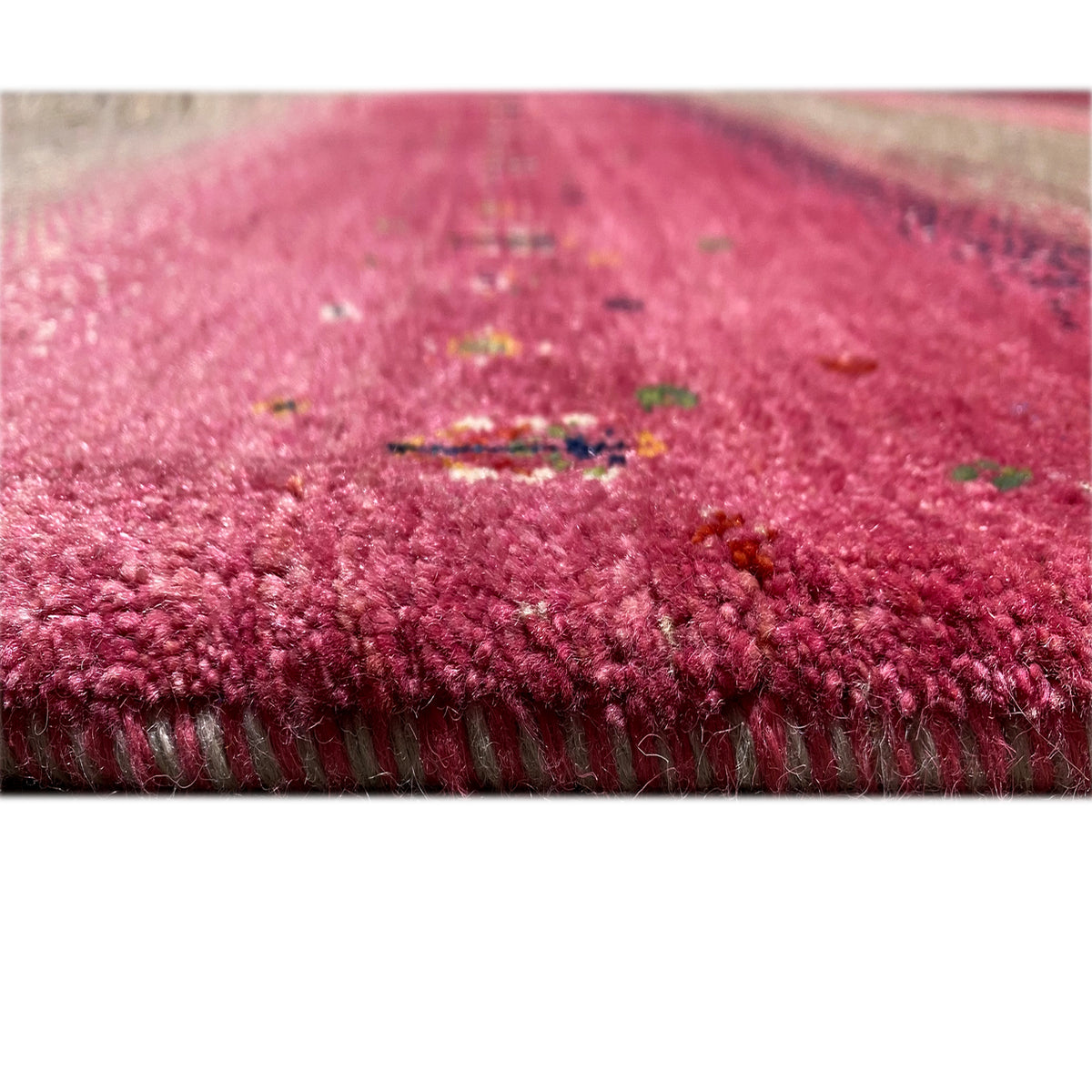 Gabbeh rug close-up: pink pile with a clearly defined edge