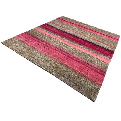 Gabbeh rug viewed from above at an angle: horizontal stripes in pink and gray