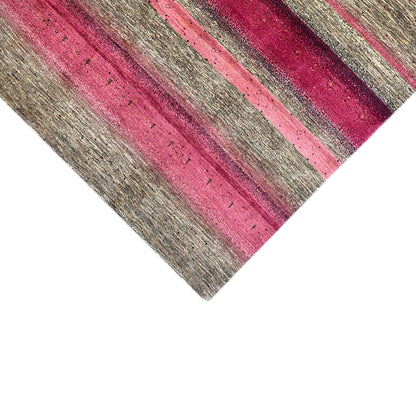 Close-up of a Gabbeh rug: narrow pink and gray stripes on a light pile