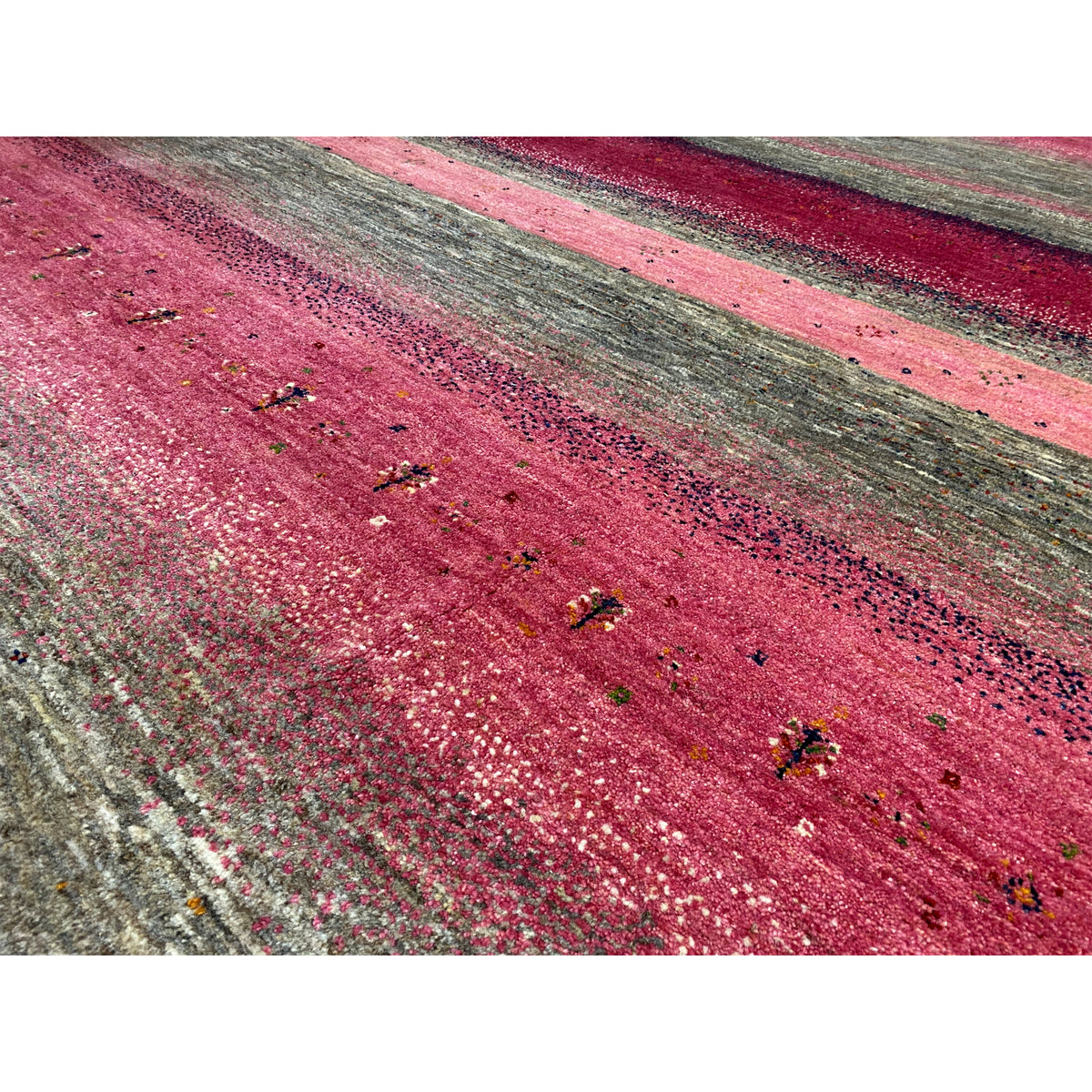 Gabbeh rug detail: mottled fibers, pink and gray with colorful dots