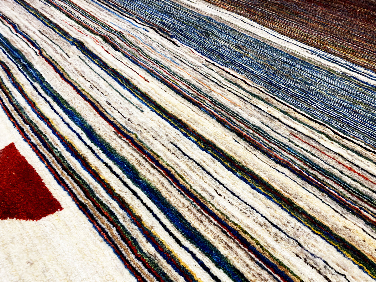 Gabbeh-Teppich Detailansicht: dichtes Streifenmuster in Creme, Blau und Braun.
