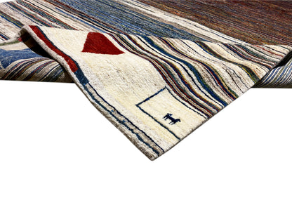 Gabbeh-Teppich Ecke mit roten und blauen Dreiecken sowie gestreiftem Hintergrund, rechteckig.