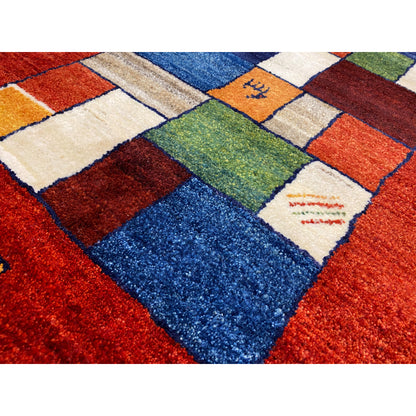 Close-up: red carpet with colorful squares in blue, orange, green, and beige