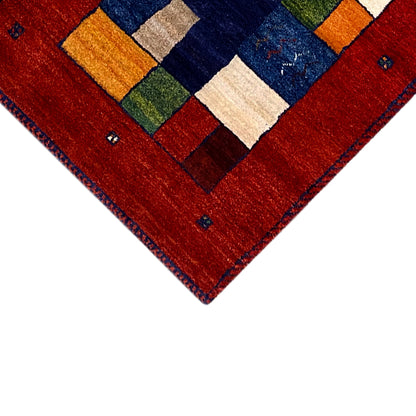 Close-up of the carpet edge: red runner with colorful squares and dark decorative trim