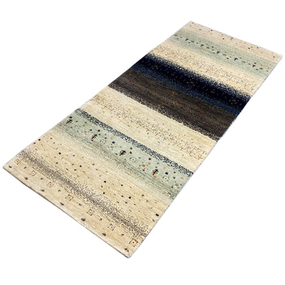 Gabbeh runner rug: light base, broad dark areas, and individual colorful ornamental motifs