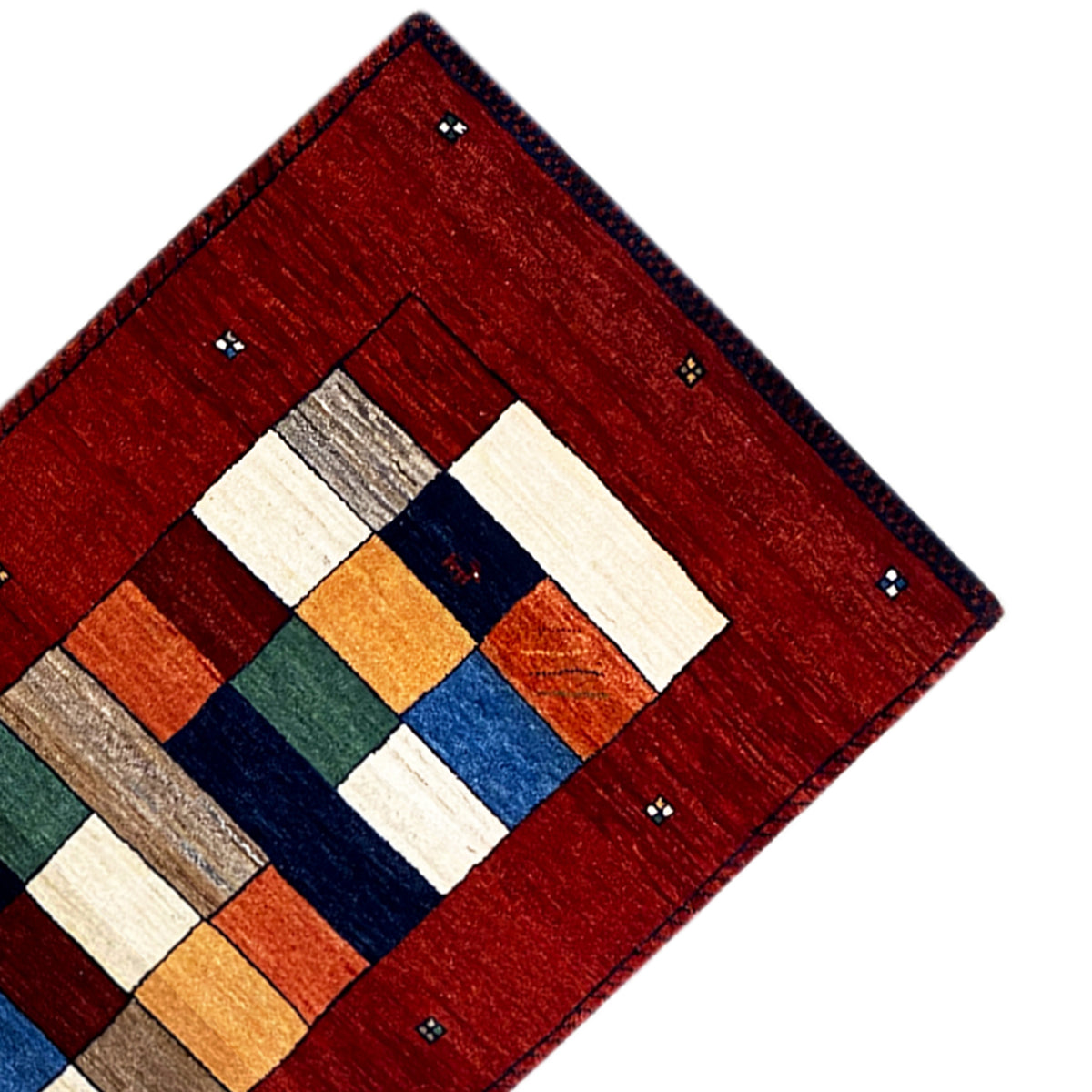 Corner view: red Gabbeh runner with geometric blocks, bordered with bobbles
