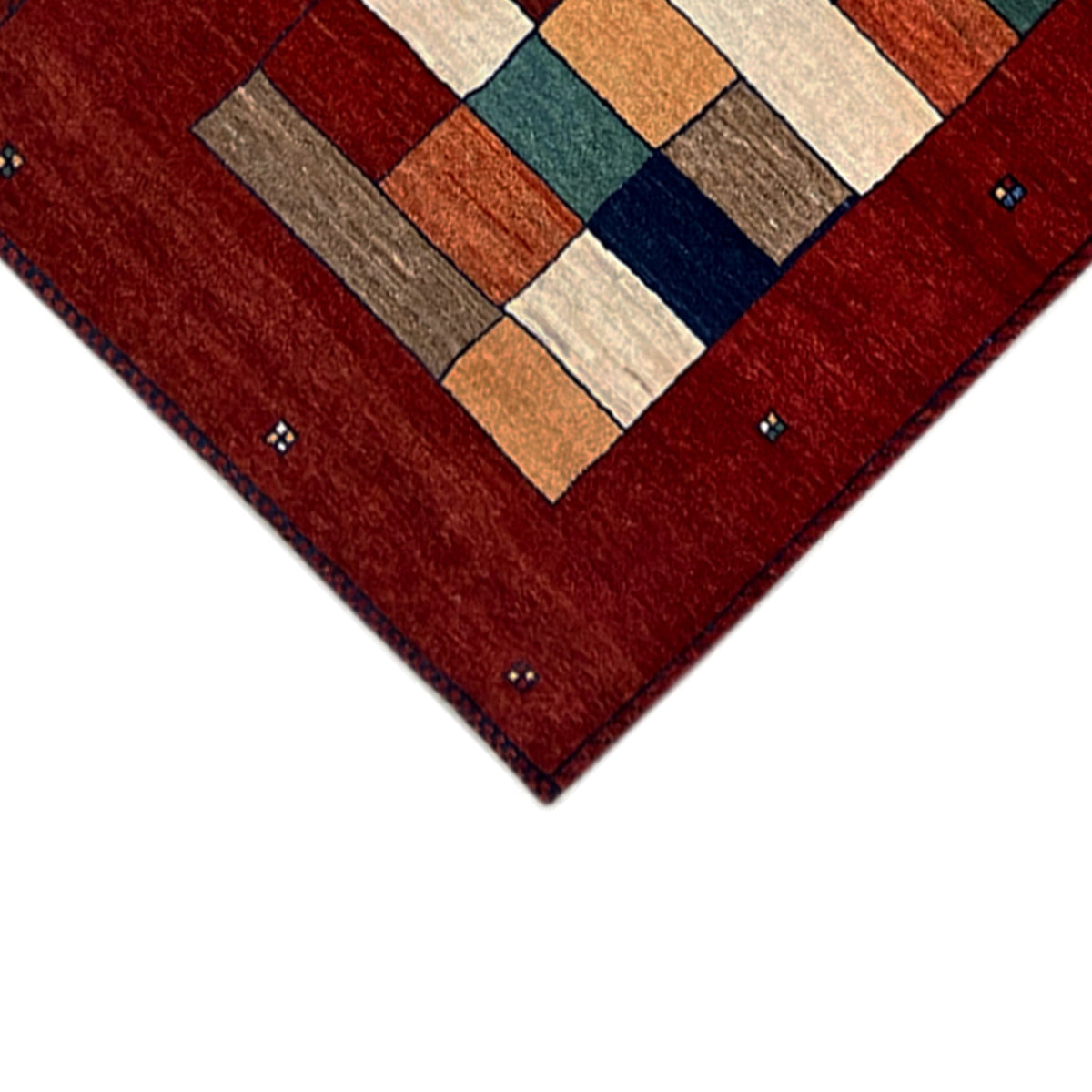Gabbeh rug runner corner with a checked block pattern in shades of red, blue, and beige