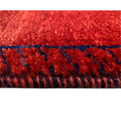 Edge view: red carpet with blue trim and short fringes along the edge
