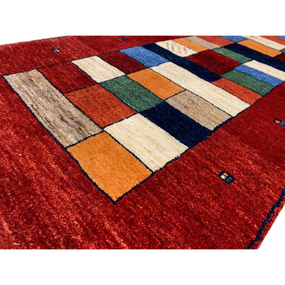 Gabbeh runner rug detail: red area with a colorful square pattern and a nubby edge