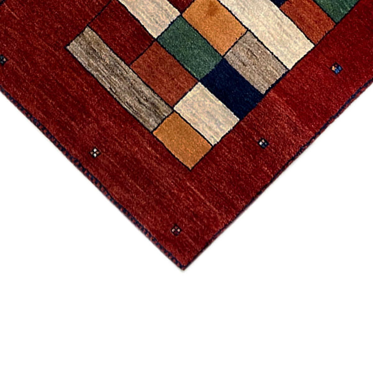 Gabbeh rug runner corner close-up: red border with colorful square blocks