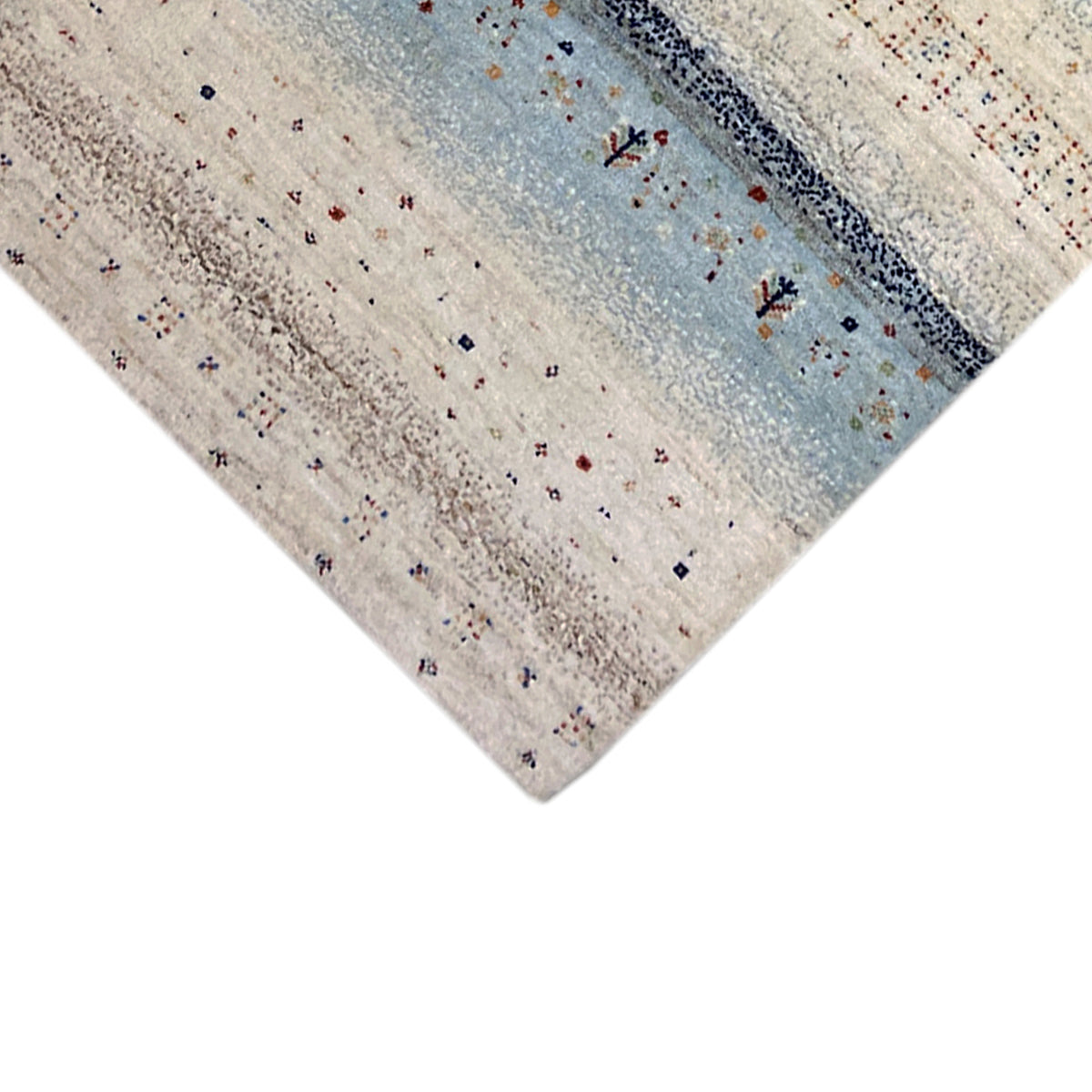 Close-up of a Gabbeh rug runner, light-colored surface with blue accents and patterns