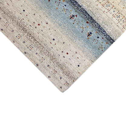 Close-up of a Gabbeh rug runner, light-colored surface with blue accents and patterns