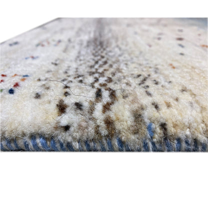 Detail of Gabbeh runner rug: pile with flecked texture and blue-gray border along the edge