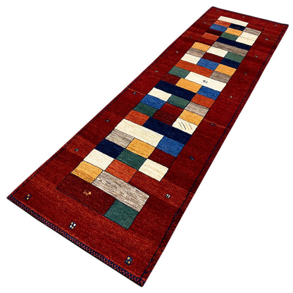 Red runner rug with a centered geometric design and colorful contrasting areas
