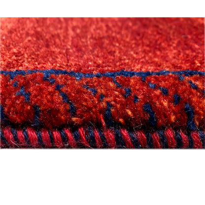 Close-up of the carpet edge: red pile with blue binding and fringes