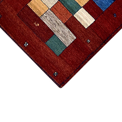Corner detail with colorful patchwork elements and a patterned border on the red carpet runner