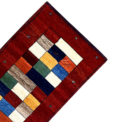Red Gabbeh rug runner corner with a geometric central motif.