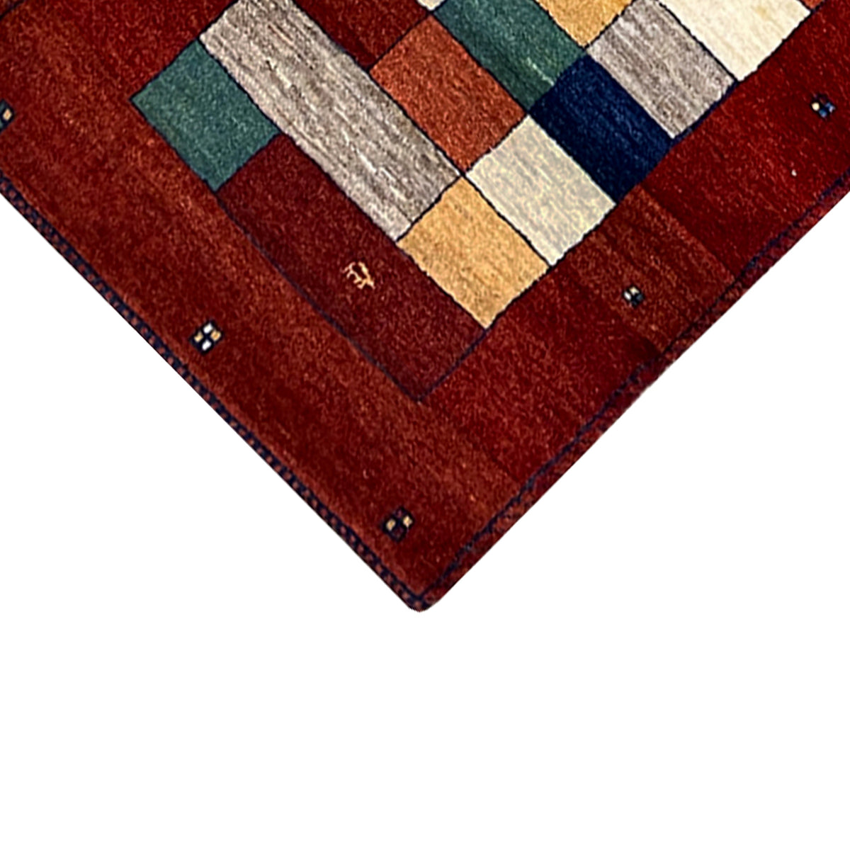 Close-up of the border of a red Gabbeh carpet runner with small decorative dots.
