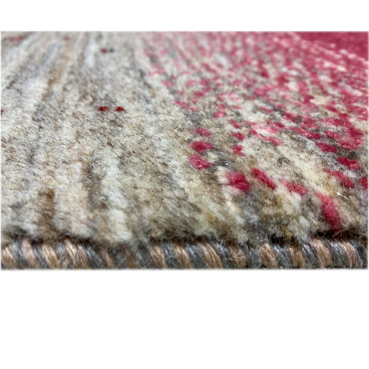 Close-up of a Gabbeh rug: beige field with red accents and a short pile