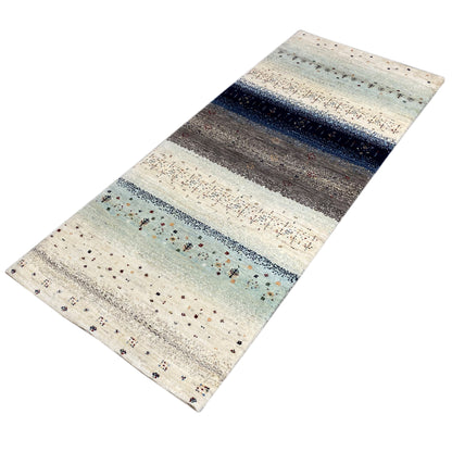 Gabbeh runner rug in angled view, light striped pattern with blue accents