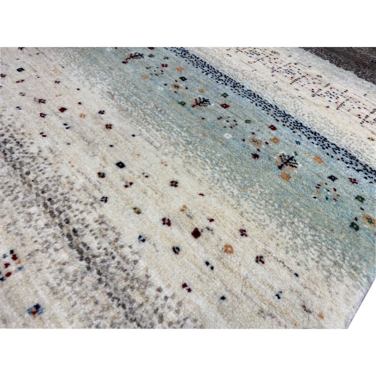 Close-up: Gabbeh rug with a short pile, cream-colored field, and small motifs