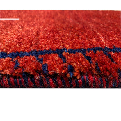 Close-up of the carpet surface: red pile with colored threads and a dark border strip