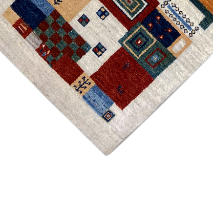 Gabbeh rug corner with a red and blue block pattern and small ornaments, multicolored