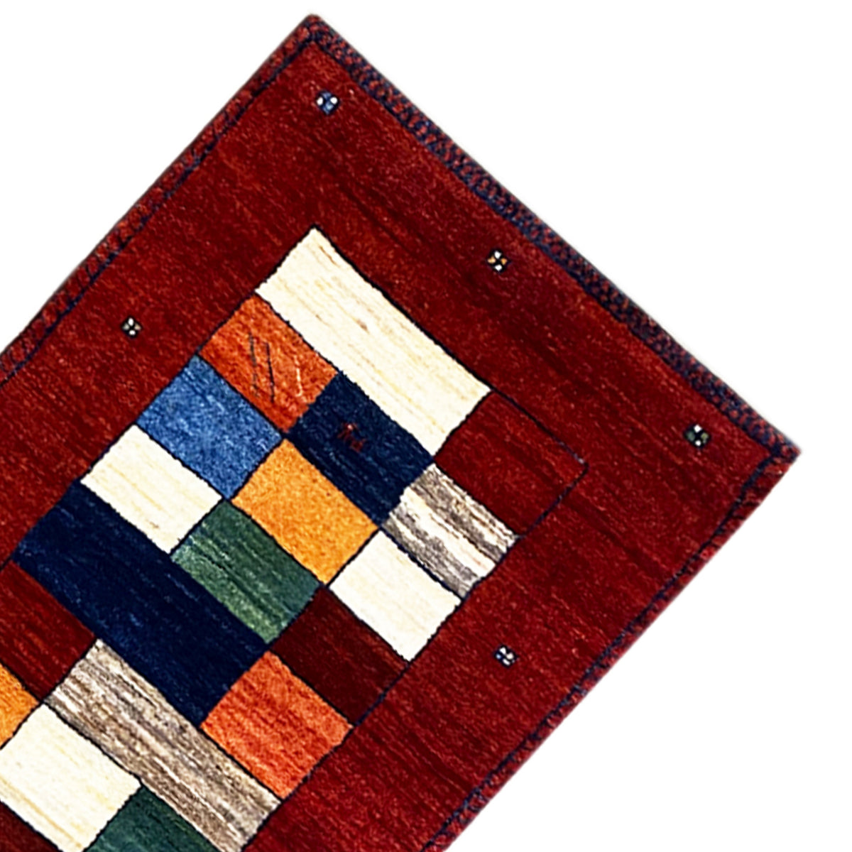 Corner of the red carpet runner with a white, blue, and orange block pattern