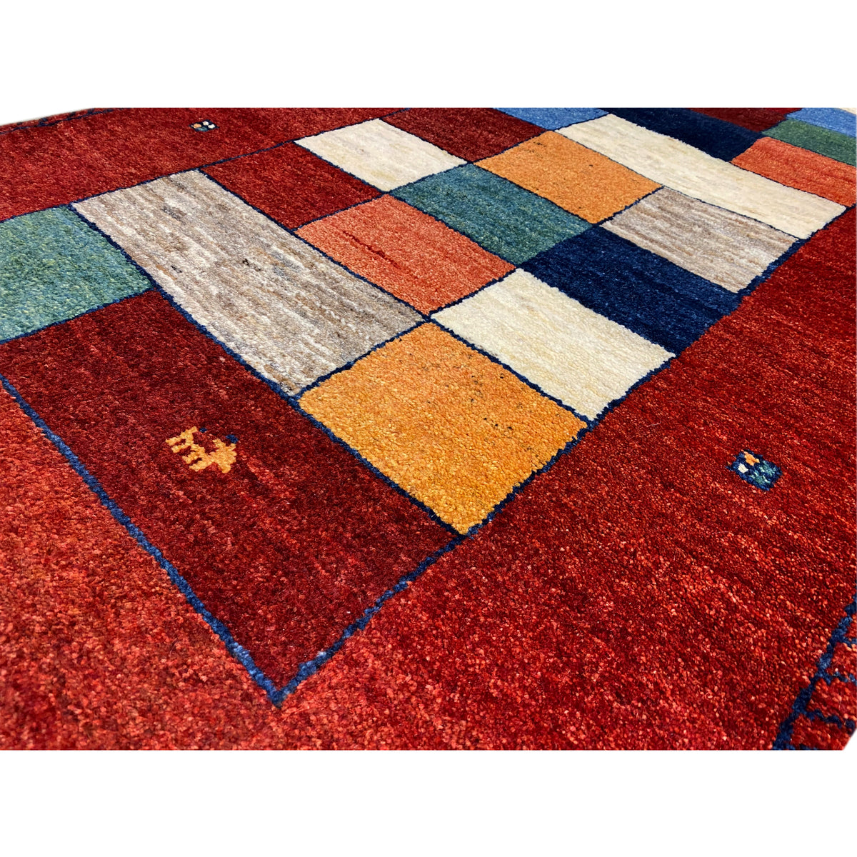 Close-up of a Gabbeh runner rug: red pattern with patchwork squares in yellow, blue, and green