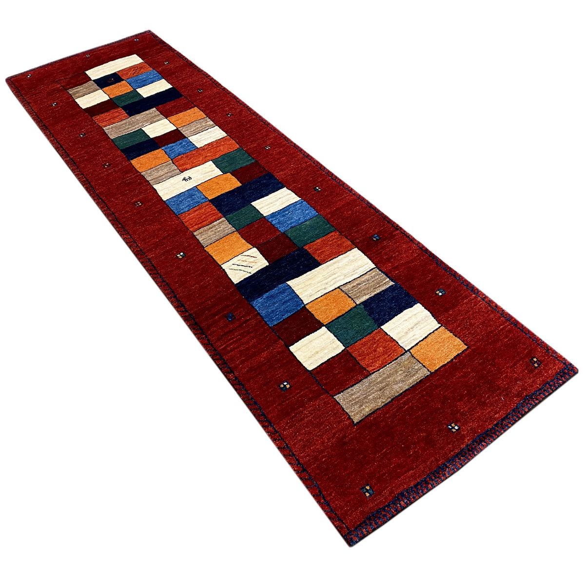 Red Gabbeh runner rug at an angle, geometric patchwork of colorful squares