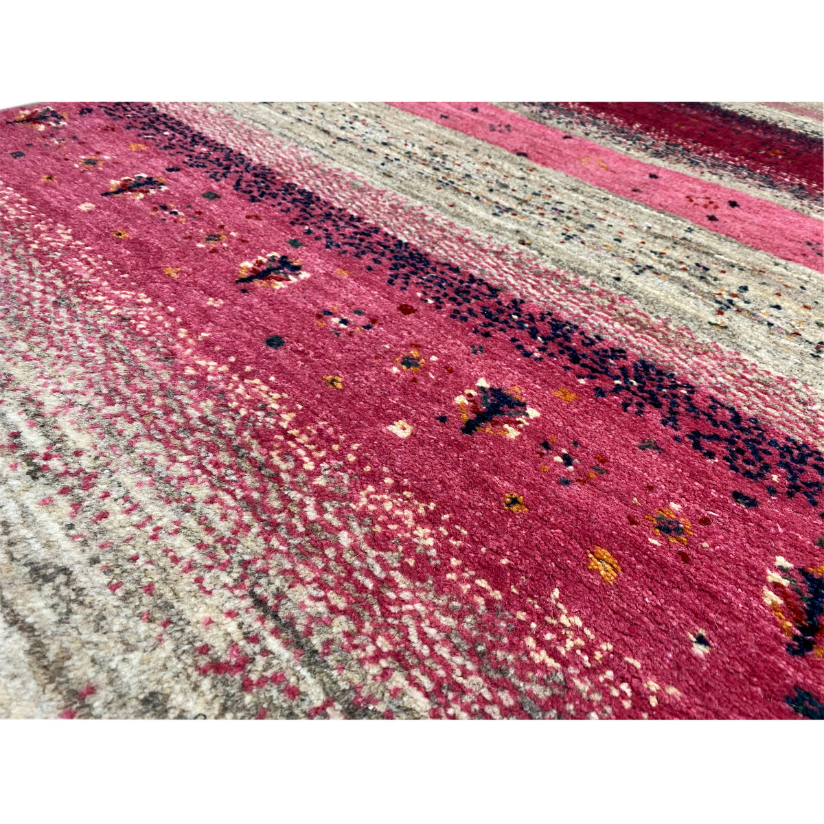 Close-up of a Gabbeh rug runner: striped pattern in pink, beige, and dark accents