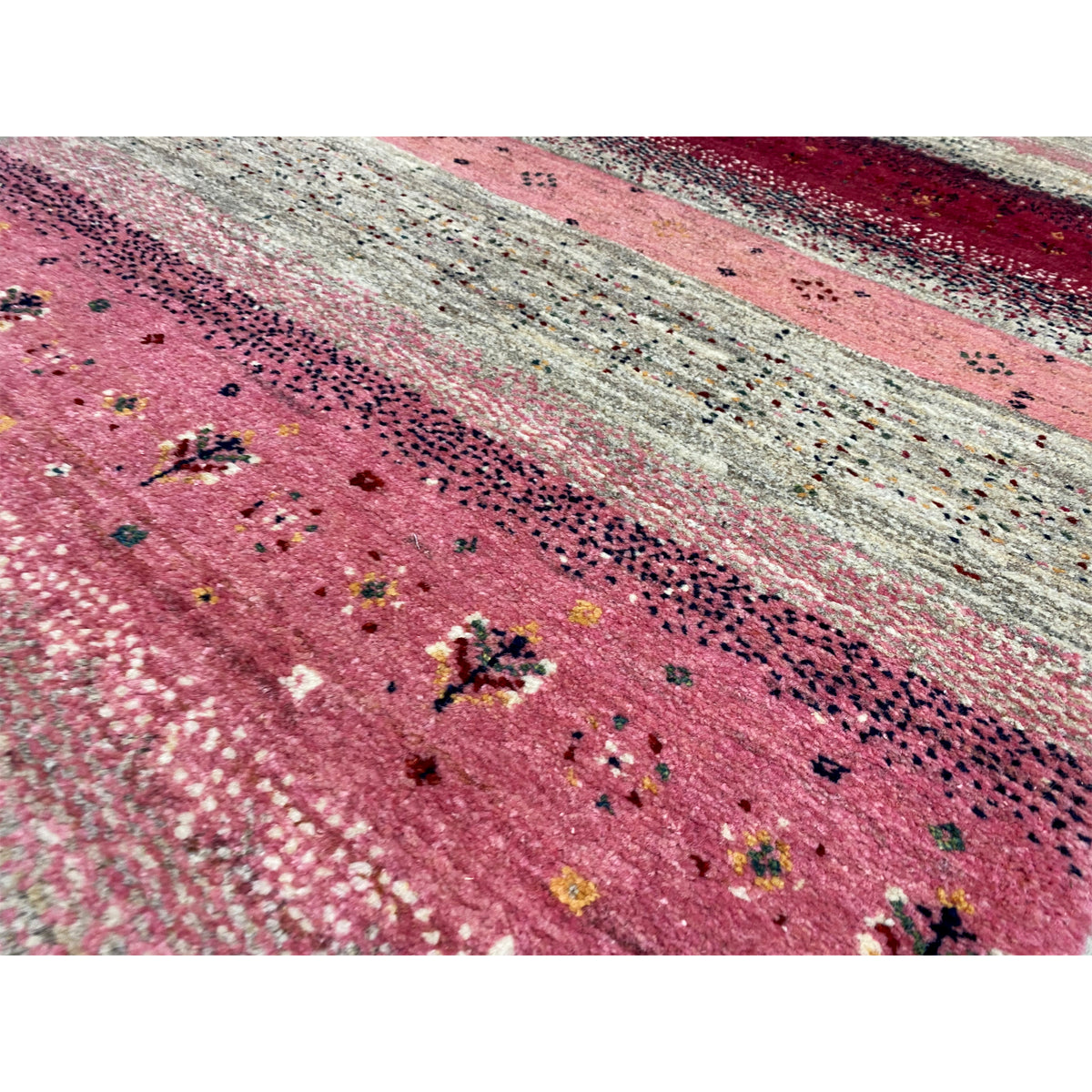 Close-up of a Gabbeh runner: pink stripes with a sequin effect and dark embroidered dots
