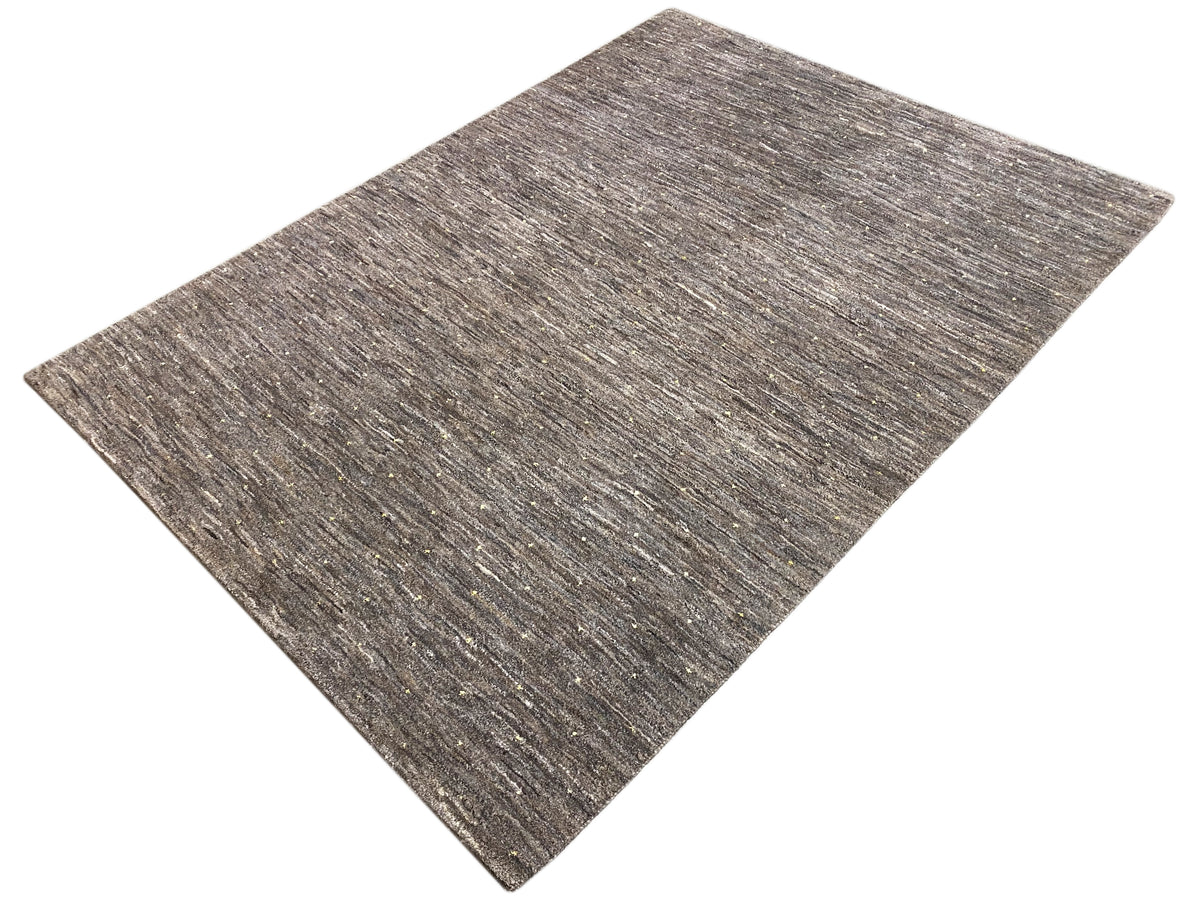 Carpet detail view: brown-gray short pile with fine light and golden particles.