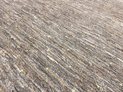 Carpet fabric in detail: fine mottled linear texture and golden flecks.