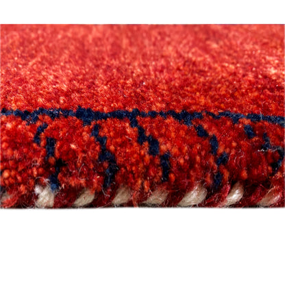 Gabbeh rug runner edge detail: red pile with a blue stripe and fringes.