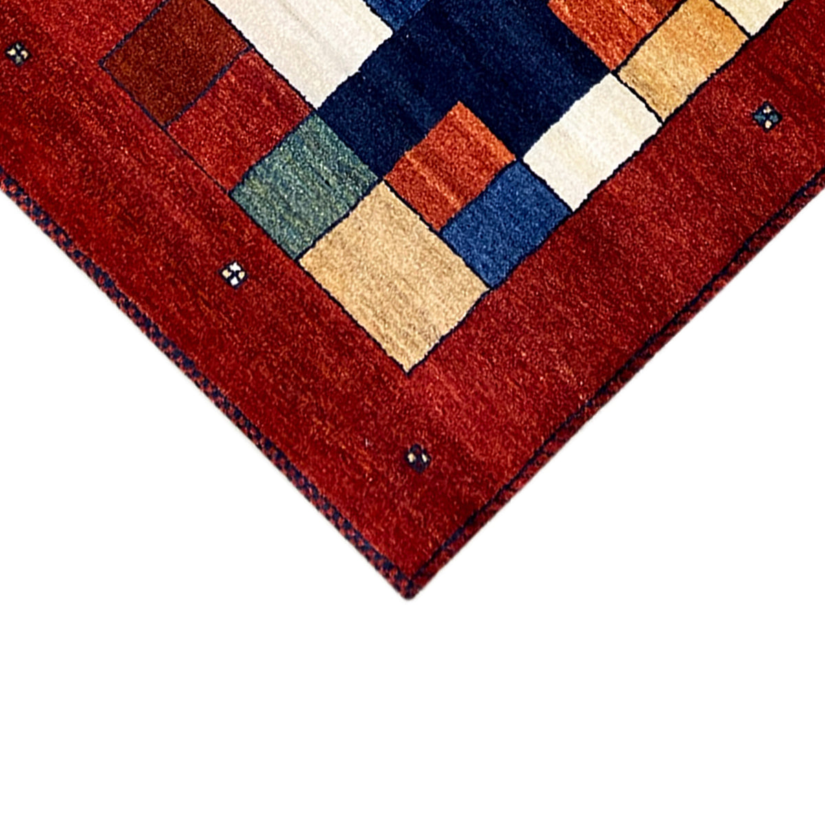 Gabbeh rug runner corner detail: red with a square pattern in blue, green, and beige.