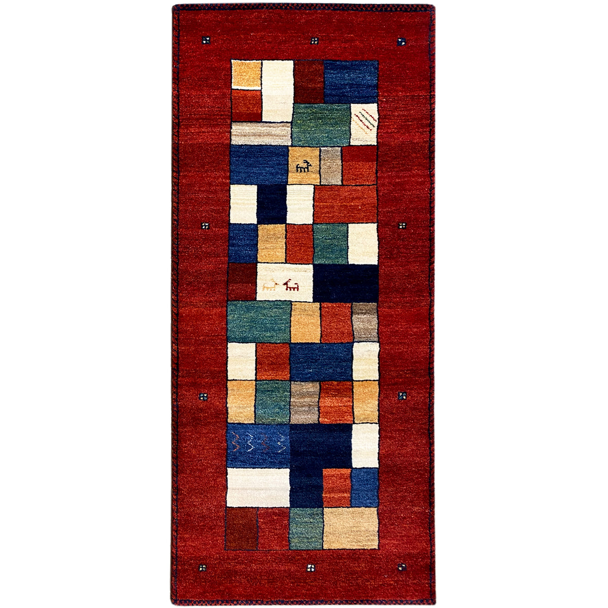 Gabbeh runner rug with a red background and geometric patchwork in blue, green, and beige.