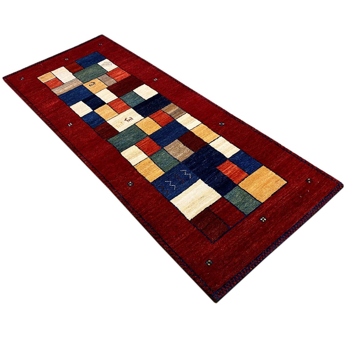 Red Gabbeh runner rug from an angled perspective with patchwork motifs in blue and beige