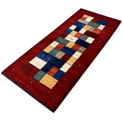 Red Gabbeh runner rug with a geometric central pattern and colorful borders