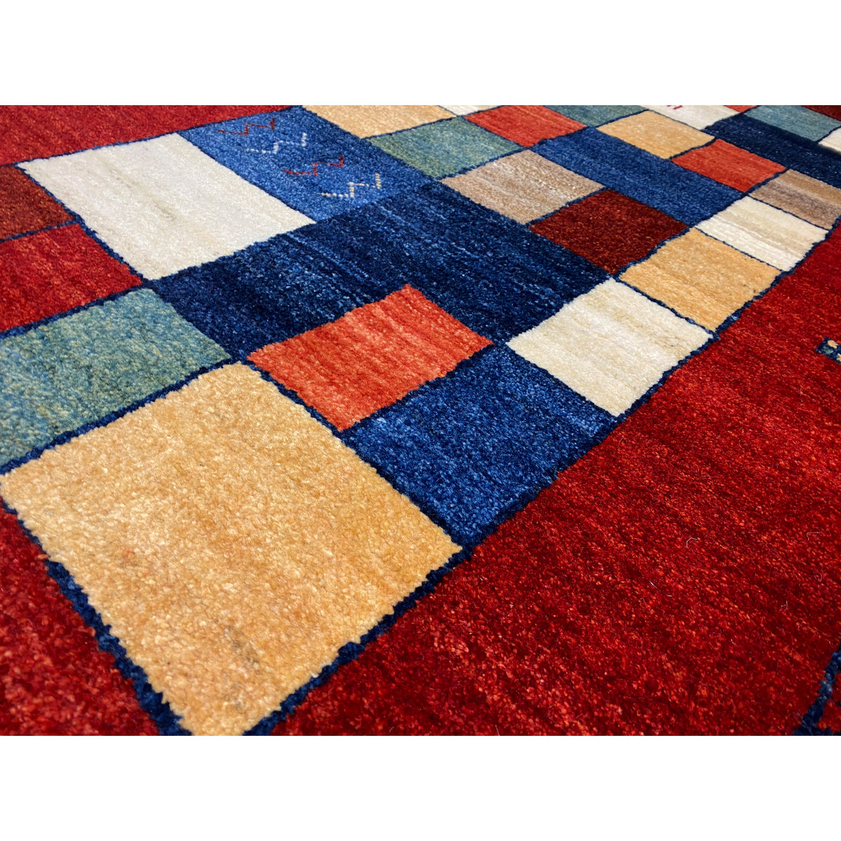 Close-up of the red Gabbeh runner rug with colorful tile and line patterns