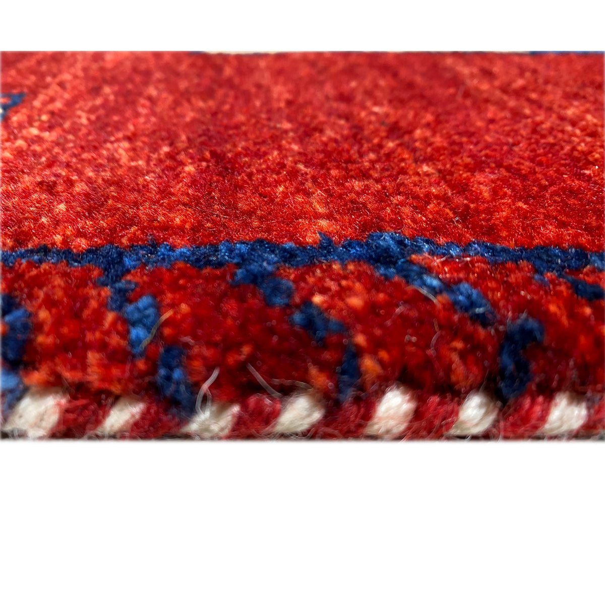 Close-up of the red carpet pile with blue pattern elements along the edge