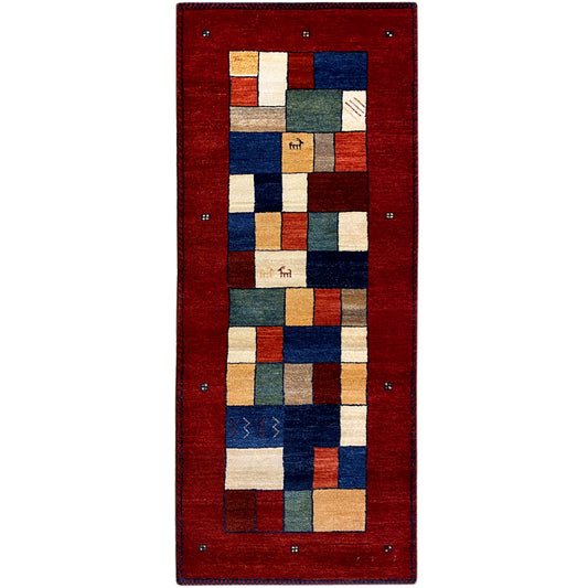 Red Gabbeh runner rug with geometric patchwork in blue, beige, and green