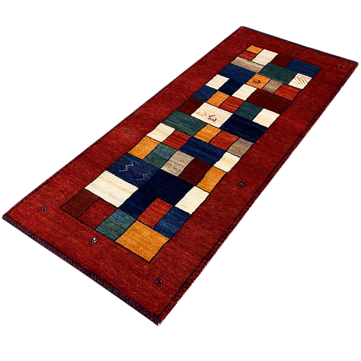 Gabbeh runner rug from above: red patchwork with orange, blue, green, and beige accents