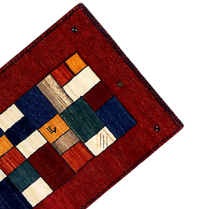 Gabbeh rug runner corner with a red border, blue block, and white rectangles