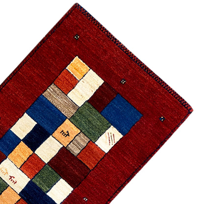 Red carpet runner with a central square pattern in blue, green, orange, and beige.